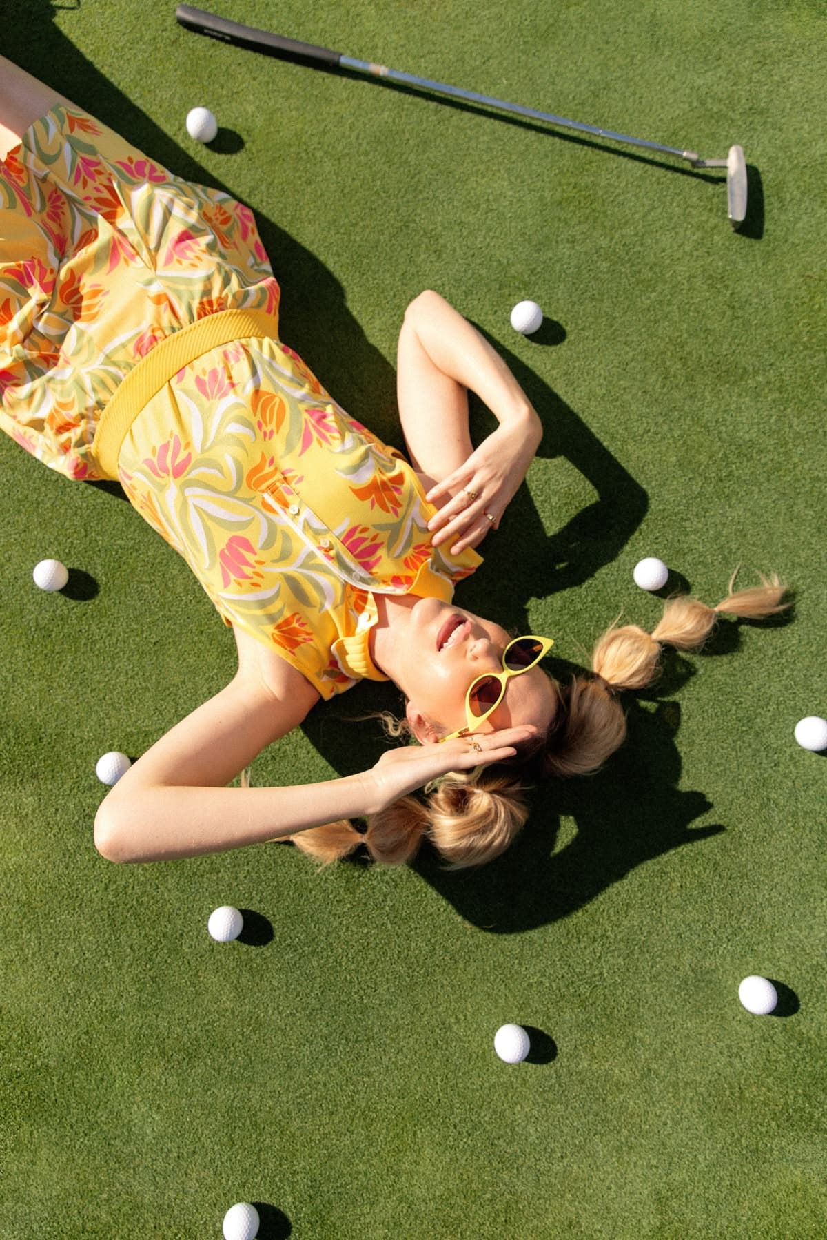 A golfer lying among scattered balls