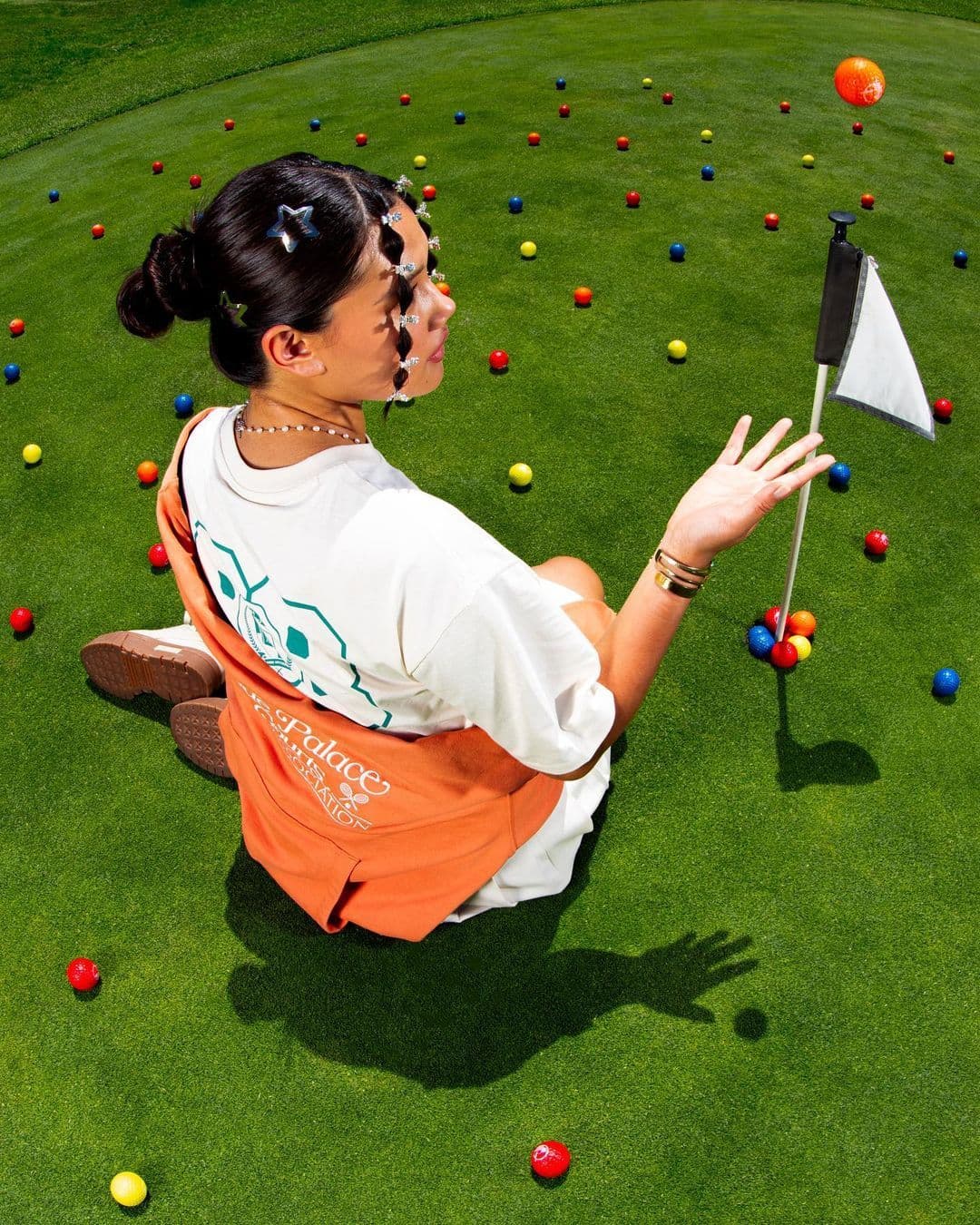 A golfer sitting on the green with the flag